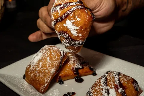 Beignets with powdered sugar and chocolate sauce